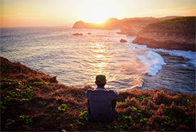 Man sitting by the ocean