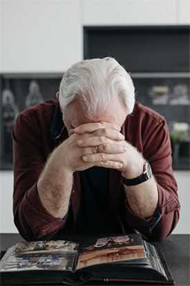 Man grieving a loved one while looking at old photos