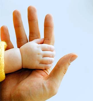 Baby's hand holding an adult's hand