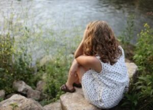 Woman Sitting On Rocks