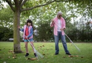 Father and Daughter Raking Leaves