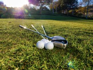Golf Clubs and Balls on Green